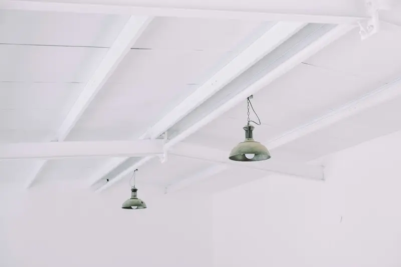 Plafond blanc à poutres apparentes avec deux suspensions